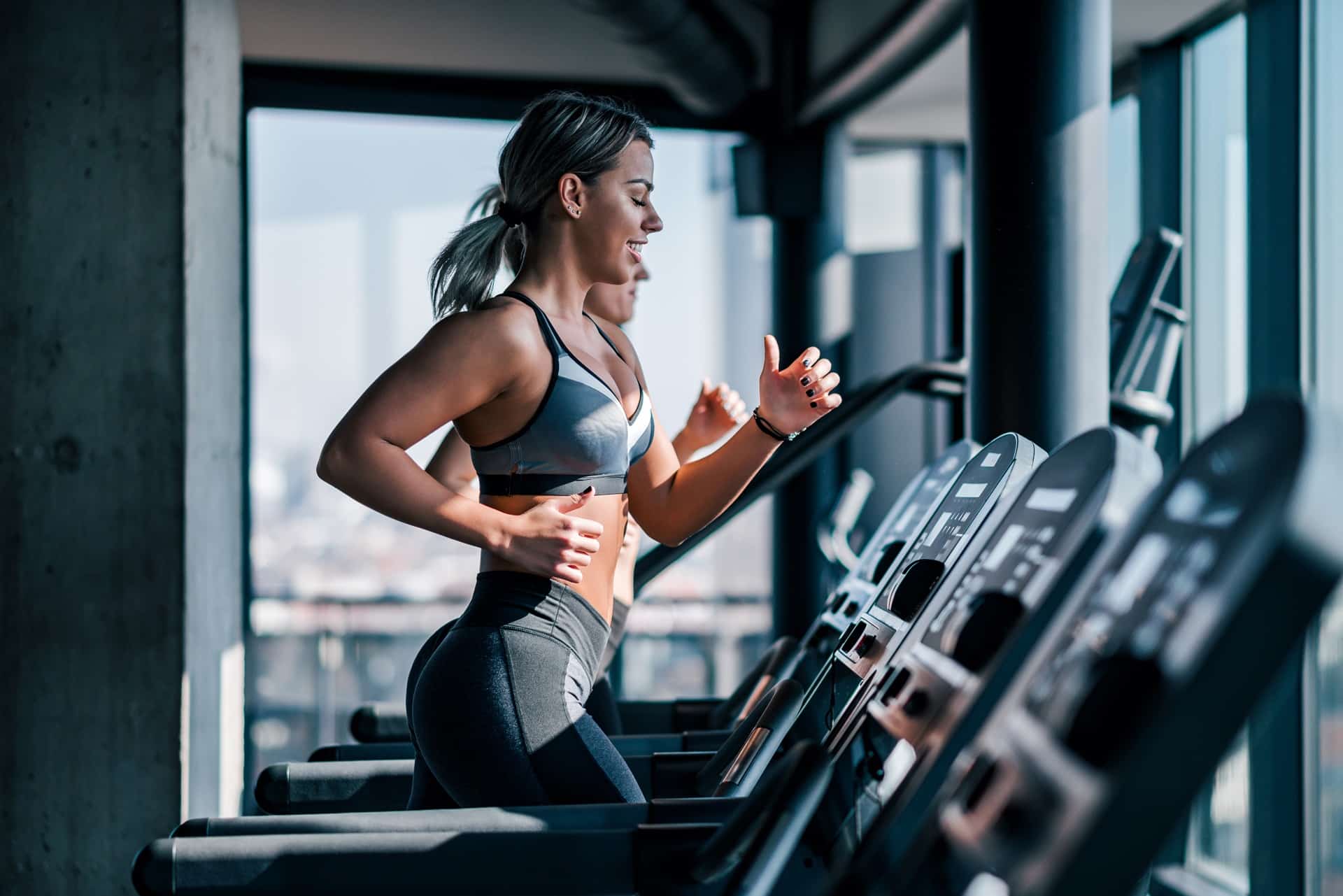 Frau joggt im Fitnessstudio auf Laufband | Maryliq